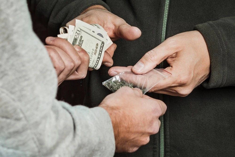 A person exchanging money for drugs