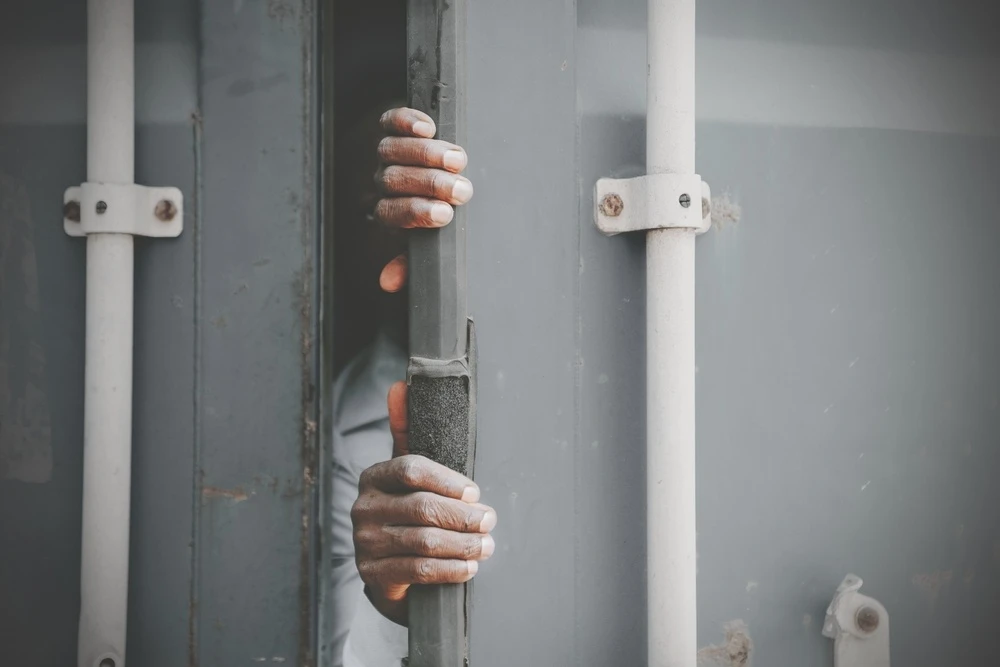 A pair of hands emerging from inside of a freight trailer