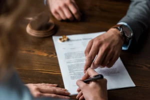 Divorce lawyer pointing at where to sign on the divorce paperwork.