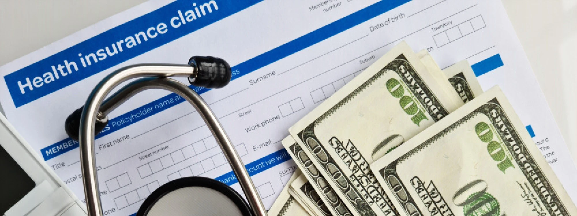 A health insurance claim form, a stethoscope, and money