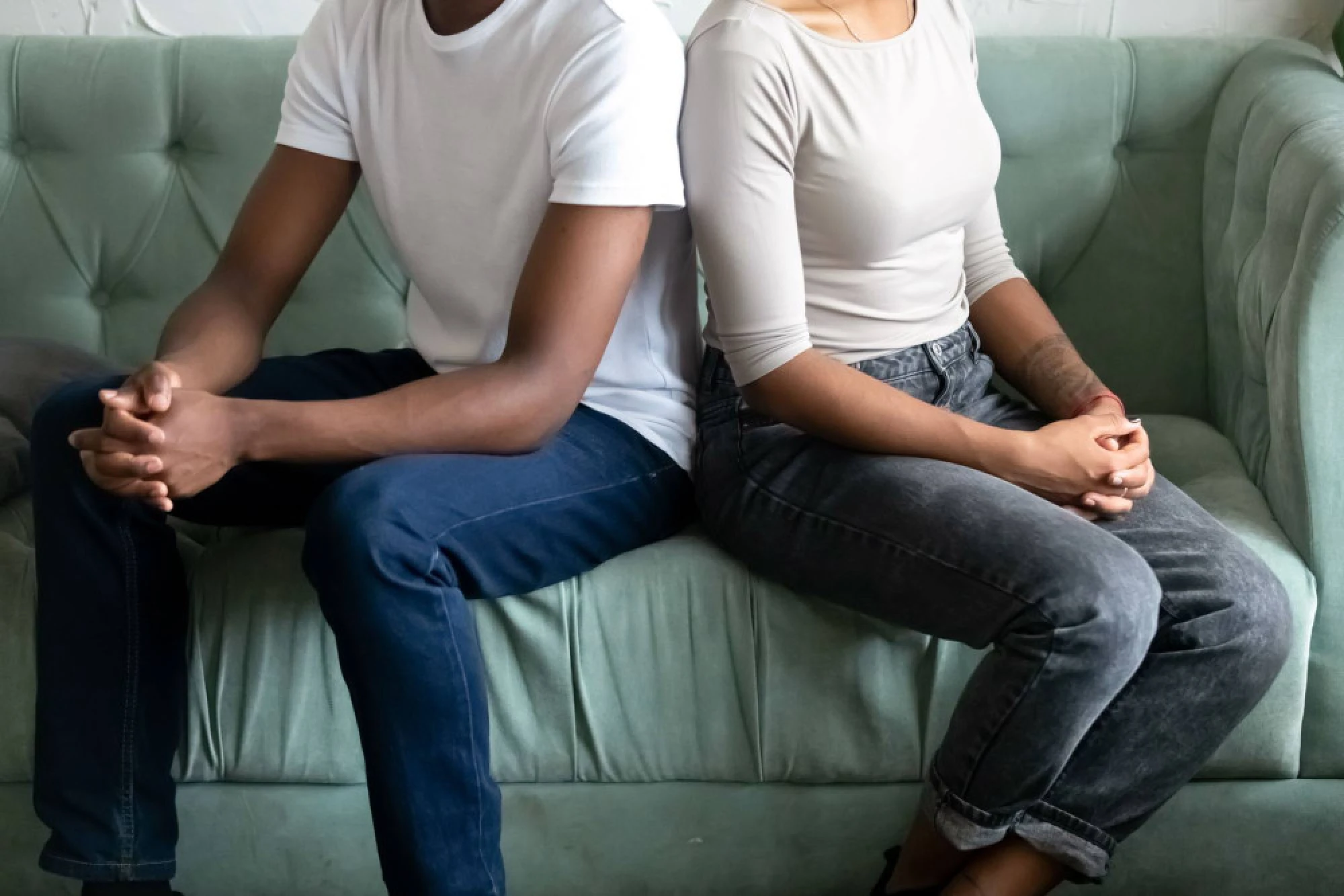 Married couple on a sofa facing away from one another