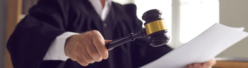 A judge holding legal documents and a gavel