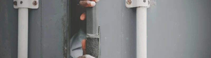 A pair of hands emerging from inside of a freight trailer